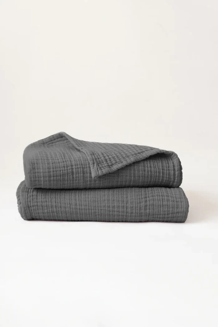 Folded anthracite handwoven muslin towels showing the breathable 4-layer cotton texture by VivaMaison