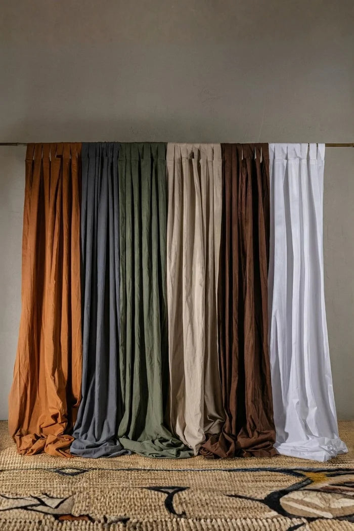 All six colors of the handwoven stonewashed cotton curtain panel, tab top, on a wooden rod. Handwoven in Denizli, OEKO-TEX. Vivamaison.