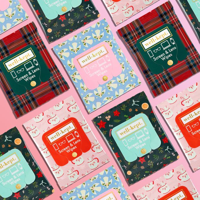 Grid of assorted Well-Kept screen and lens wipes packs in holiday patterns, including plaid, reindeer, and pink prints